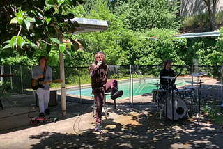 From a (now deleted) live video; five Christians in a spilt screen effect playing instruments in front of a backyard pool shaded by trees — left to right keyboard, guitar, vocals, drums, bass guitar — vocals has left leg kicked up