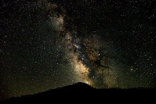 The Milky Way Galaxy stretches across the night sky.