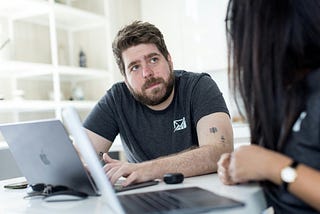 Colleagues discussing work in front of a laptop
