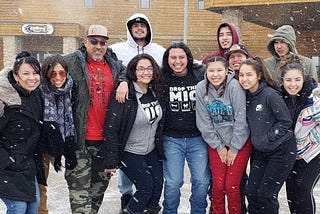 An image of participants in About Face’s training at Cheyenne River, smiling on a snowy day.