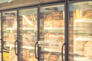 supermarket freezer showing four doors processed food packaging where there is probably no fibre.