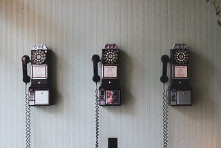 An image of rotary pay phones mounted on a wall