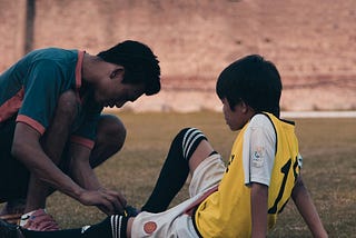 A soccer coach helping a young player