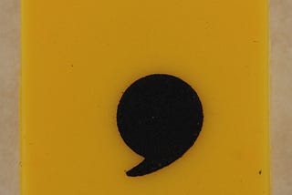 A large yellow square with a black comma near the bottom middle.