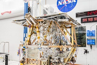 The VIPER lunar rover in a clean room at NASA’s Johnson Space Center with its mast installed. The rover is not fully assembled yet. It lacks its wheels and exterior in particular.