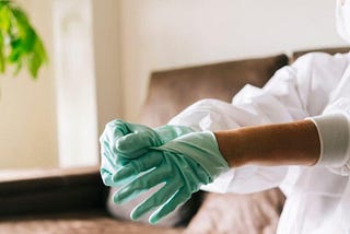 A technician wearing full personal protective equipment (PPE), preparing for a professional sewage cleanup. The image emphasizes the importance of safety assessment and setup during cleanup services.