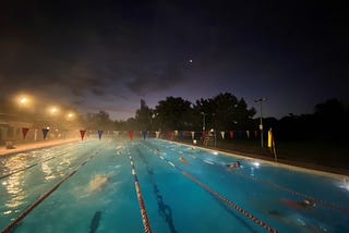 An outdoor floodlit swimming pool