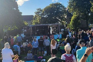 Crowd of revellers outside an outdoor festival stage.