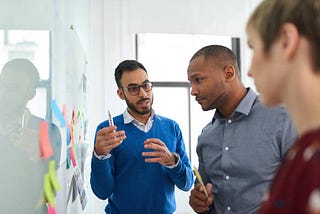 Multi-ethnic group hipster trendy business people with Indian boss discussing during a brainstorm session for their small company