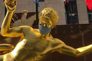 Gold statue in Rockefeller Center wearing a blue mask