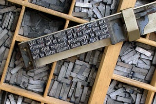 Imagem dos clichês (peças de metal) posicionados em uma prancha pronta para ser prensada.
