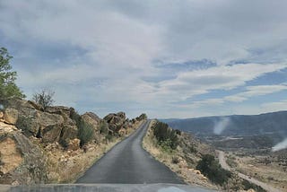 SKyline Road in Colorado, a narrow road with a dropoff to the right and rocks to the left.