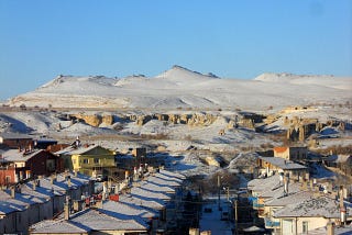 A snow-covered town at the foot of the mountains.