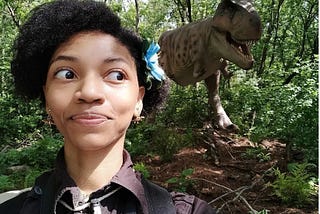 me looking back at a dinosaur at the Detroit Zoo’s Dinosauria exhibit with a look on my face that isn’t the bravest. God bless you!