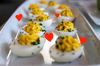 Red hearts adorn a tray of deviled eggs