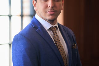 Professional headshot of the author wearing a suit and tie.