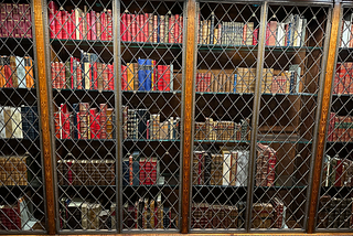 An old, classic bookcase at the Morgan Library with hundreds of books lining the shelves