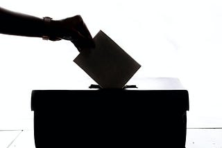 Hand dropping a ballot into a ballotbox