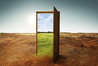 a constructed image of an open door in the middle of a dry field. Through the door, we see a green field and blue sky.