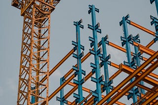 Crane and steel construction against sky