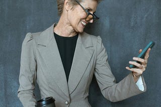 Woman in Gray Blazer Holding Black Tumbler