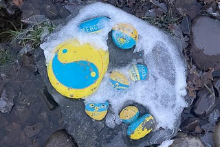 Painted rocks in blue and yellow indicating support for Ukraine