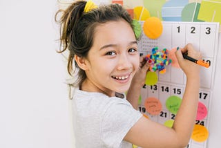 Smiling girl using a sticker chart