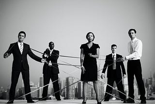 Five business people connected by string