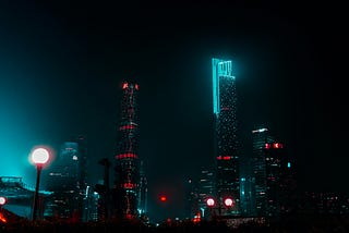 A night cityscape with buildings lit up in neon colors
