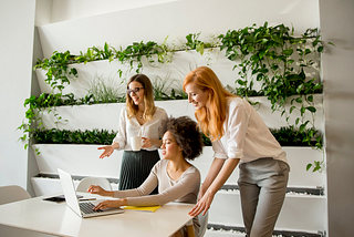 Three women working at a laptop