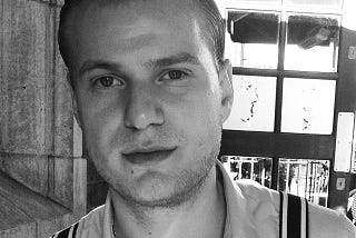 A black-and-white image of the author in his mid-twenties, with Brylcreemed hair, donning 60s clothing inspired by the TV series Mad Men.