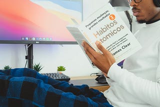 Person holding a book called Atomic Habits