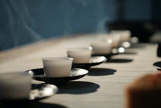 A line of traditional tea cups with steam rising