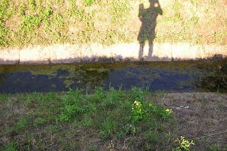 Child’s shadow near a stream.