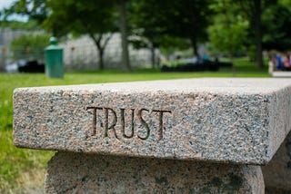 A stone bench with Trust engraved on it
