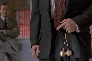 Scene from the movie Glengarry Ross — Alec Balding holding brass balls in front of his pants.