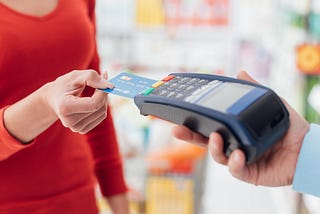 Woman wearing red at the checkout in a physical store