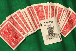 Playing cards spread out with the Joker on top.