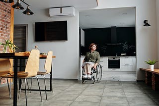 A woman in a wheelchair alone in her house