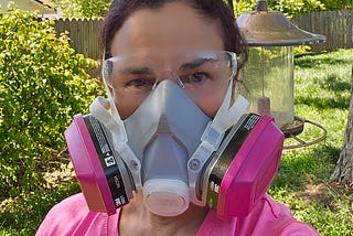 picture of author in a P-100 respirator and clear eye glasses in her yard