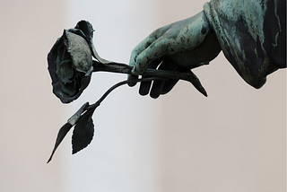 statue of a hand holding a flower