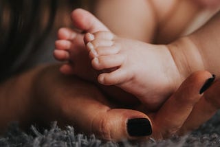 A mother cradles her tiny baby’s feet