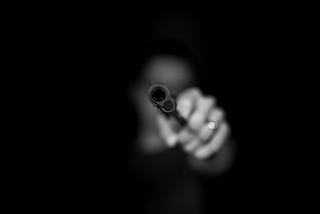 A person holding a gun pointed towards the camera