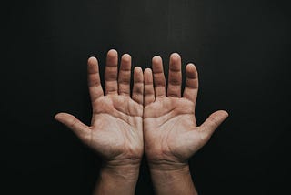 Photo Of Person’s Open Hands on a dark background