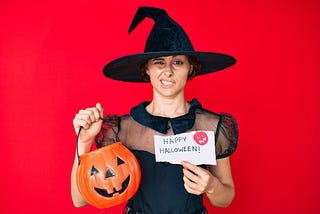 Adult looking uncomfortable dressed as a witch for Halloween