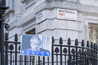 An image of a sign with Boris Johnson’s image with the word “resign”