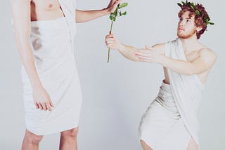 Re JECT ed. Man in toga offers flower to another man in a toga, who rejects it.