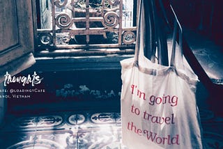 Image of a canvas bag that says I’m going to travel the world, on a chair looking out of a window. Cafe Thoughts Blog Post