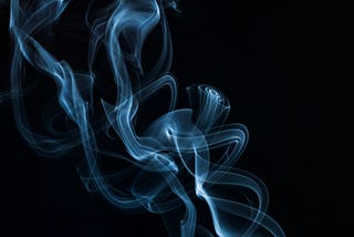 Whisps of smoke against a black background