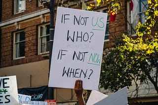 Photo of a board for the climate saying if not us who? If not now when?